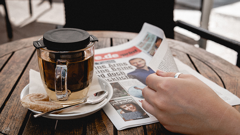 Zeitung mit Tee und Hand_web.jpg